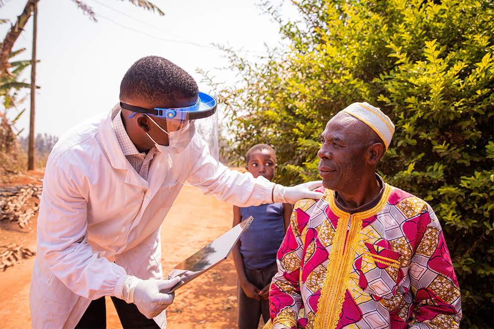 African doctor visits an elderly patient and they converse during the medical examination.